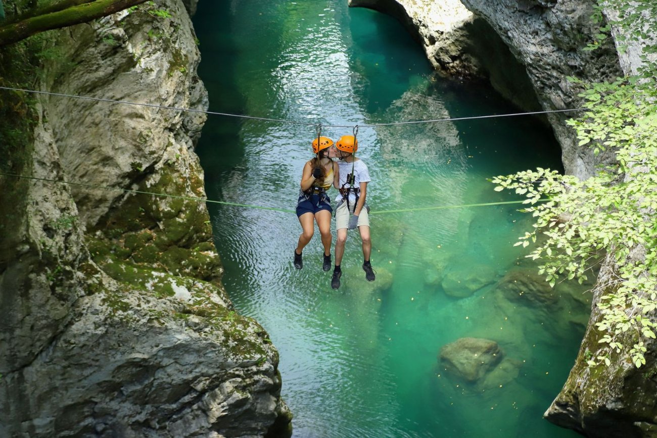 Coppia in zip line sospesa nel canyon al Canyon Park
