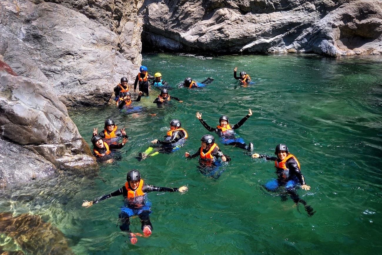 gruppo di partecipanti che galleggia nell’acqua verde del canyon, durante il Riverplay nelle Gole di Cocciglia
