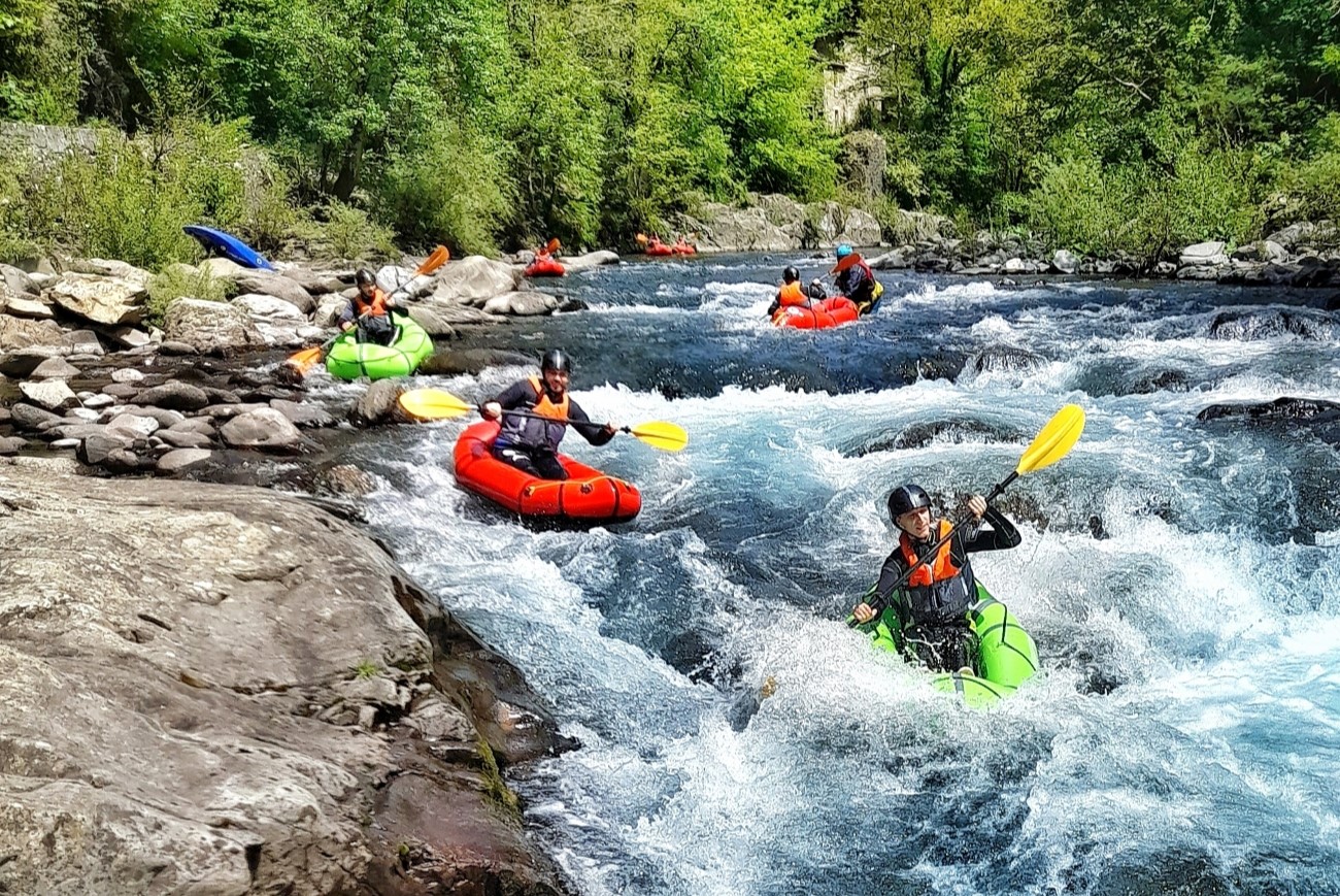 Gruppo di amici impegnato in una discesa rafting estrema durante un addio al celibato avventura in Val di Lima, Toscana.