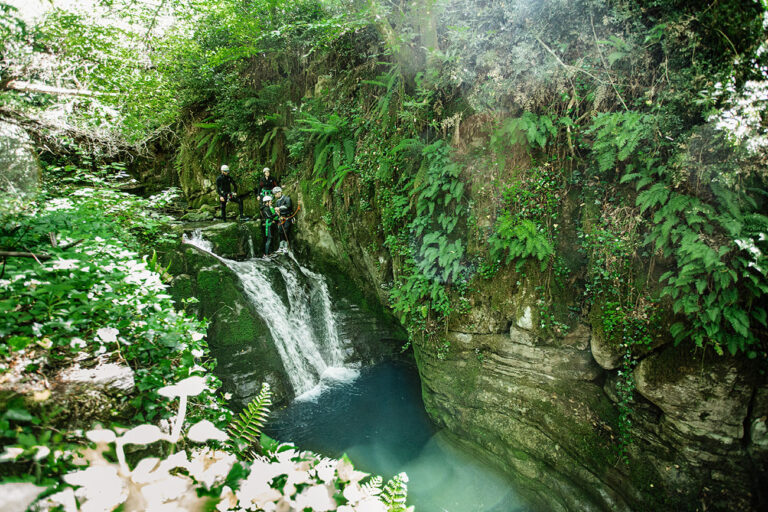 discesa da cascata di fiume in Toscana durante un'avventura di canyoning in estate