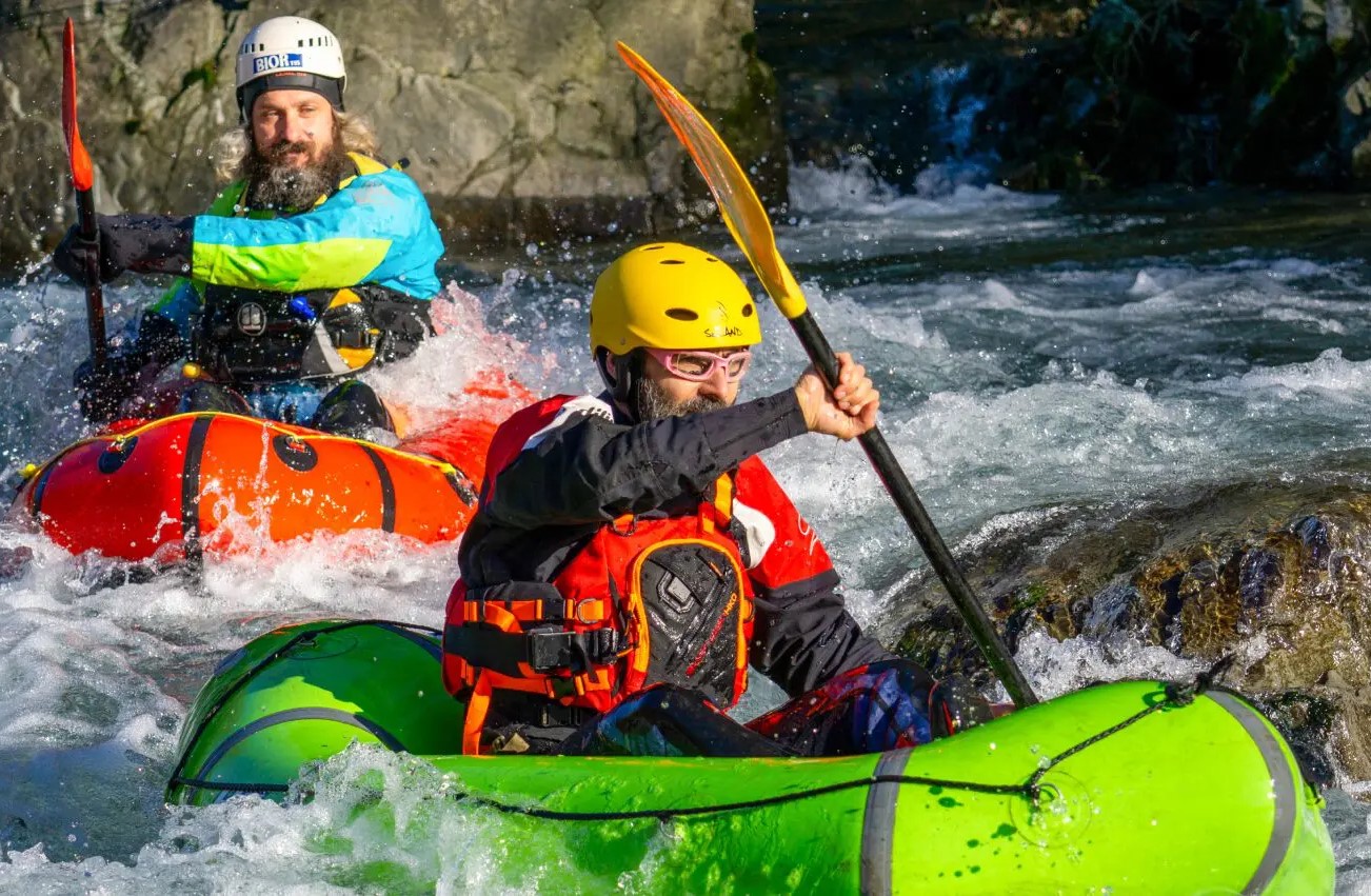 Due packrafter affrontano le rapide del Torrente Lima in Toscana con imbarcazioni gonfiabili monoposto, guidati dalla scuola Rockonda.