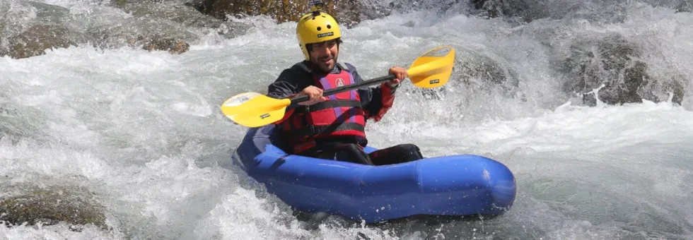 Un partecipante affronta le rapide del Torrente Lima su un packraft monoposto durante un'uscita guidata dalla scuola Rockonda.