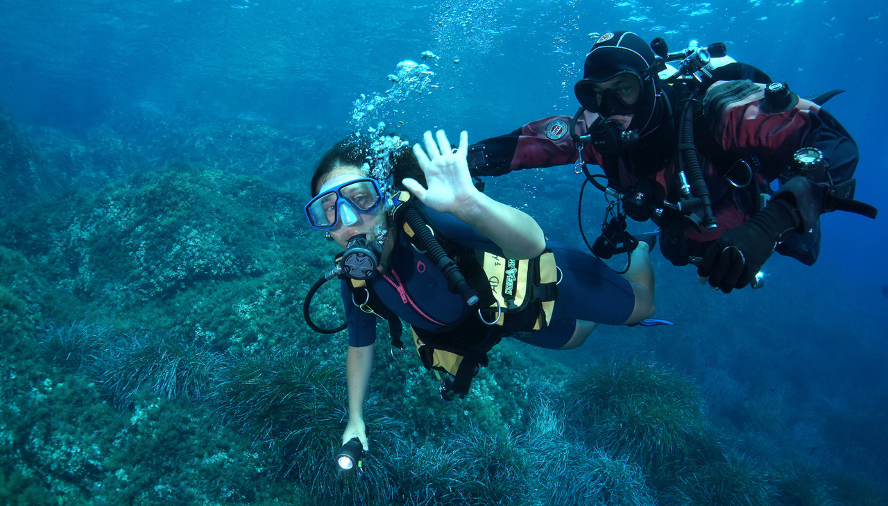 Un istruttore di Argentario Divers assiste un principiante durante il battesimo del mare
